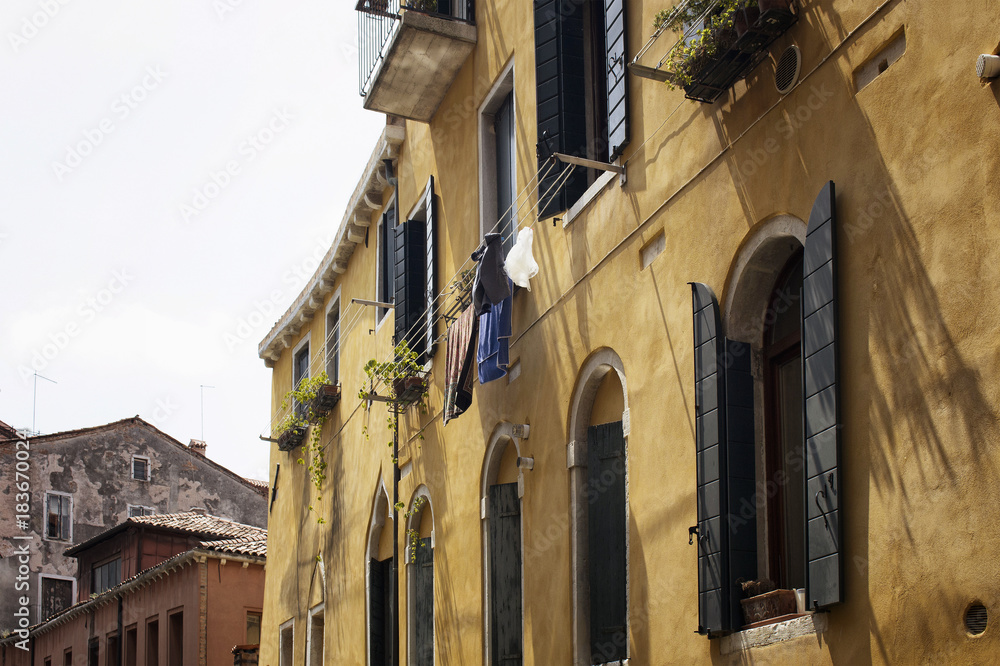 View of hung washed clothes on a old, historical, typical building in Venice / Italy. Image shows culture and lifestyle of the region.