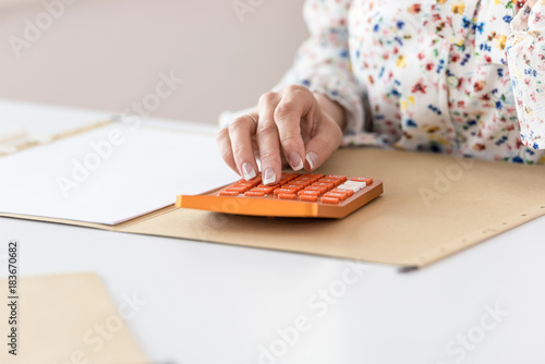 Εκτύπωση καμβά Woman calculating on orange desktop calculator