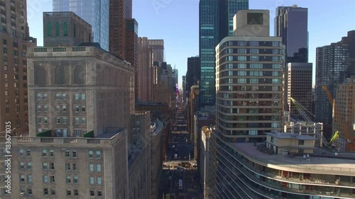 Aerial. Downtown buildings, New York. Camera flying left along West 57th Street filming 7th Avenue.