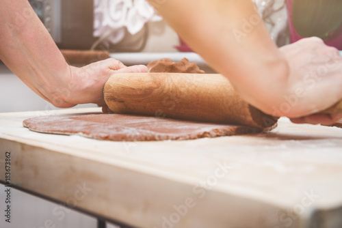 Christmas preparations. Cooking and baking concept. Kneading gingerbread, baking gingerbreads. A woman's hand rolling out the dough.