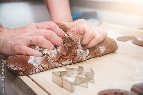 Christmas preparations. Cooking and baking concept. Kneading gingerbread, baking gingerbreads. A woman's hand kneads the dough. Cooking together and baking, family.