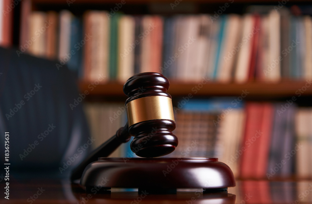 Judge gavel on wooden table in library Judge gavel on wooden table in library