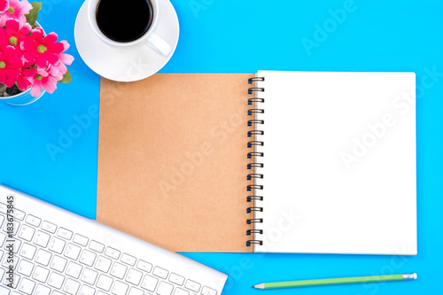 Top viwe of modern workplace with office supplies, pencil, a cup of coffee and keyboard on blue background. Flat lay designand copy space concept photo