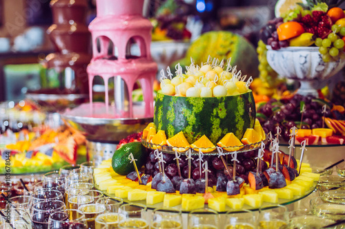 Obraz na płótnie Delicious sweets and fruits on candy buffet. Lot of colorful desserts on table. Chocolate fountain. Party catering. w salonie