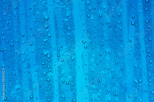 Regentropfen auf Glasscheibe mit Himmelblauem Grund © mitifoto