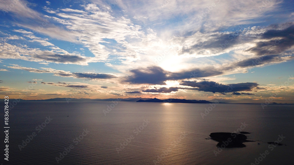 Aerial drone bird's eye view of sunset in famous coast of Voula with beautiful scattered clouds, Athens riviera, Attica, Greece