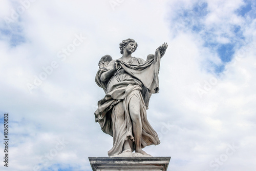 statue on Sant Angelo bridge in cloudy sky in Rome 