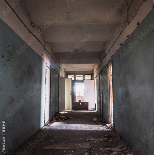 Dark creepy corridor with many doors in abandoned ruined hospital, horror hallway or tunnel