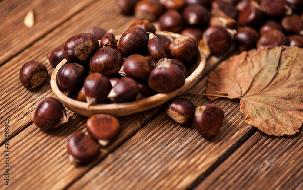 Ripe chestnuts in a frying pan on old wooden table close up with copy space. Roasted Chestnuts for Christmas'n Ripe chestnuts in a frying pan on old wooden table close up with copy space. Roasted Chestnuts for Christmas'n