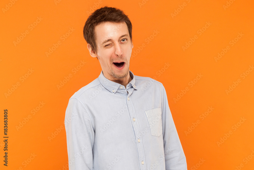 Emotional businessman wearing blue shirt, wink at camera. Emotional businessman wearing blue shirt, wink at camera.