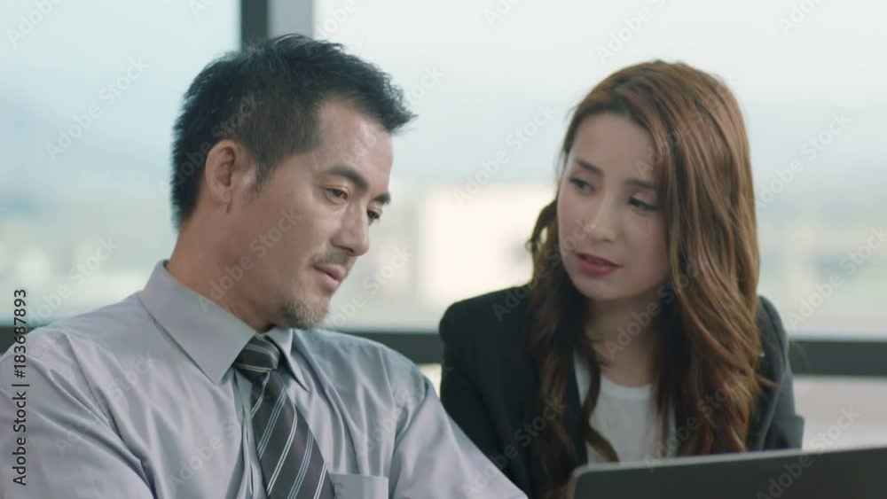 asian corporate executives working together in office discussing business using laptop asian corporate executives working together in office discussing business using laptop