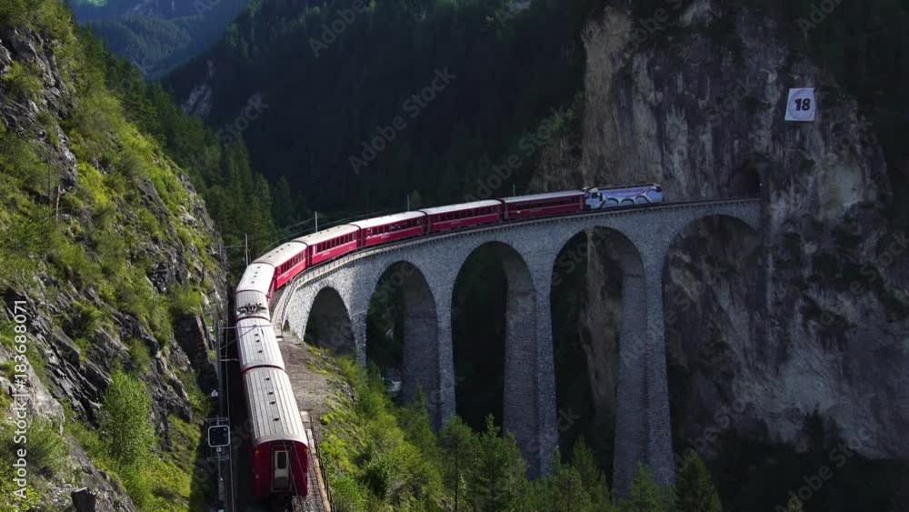 Swiss red train on Landwasser viaduct bridge on bernina pass glacier express in Switzerland