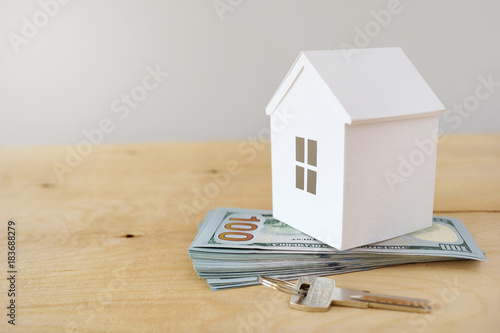 The model of the house costs on a pile of notes