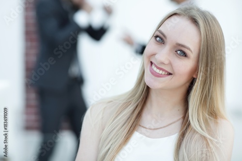 close-up portrait of a young woman against the background of colleagues