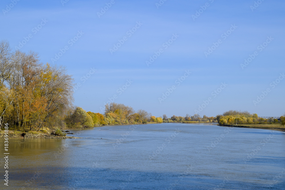 Autumn landscape. River bank with autumn trees. Poplars on the b Autumn landscape. River bank with autumn trees. Poplars on the b