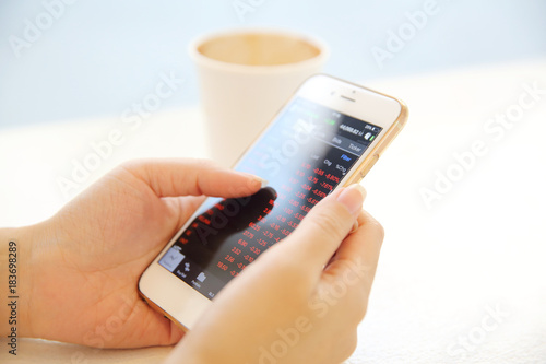 business trading online on smartphone with woman hand