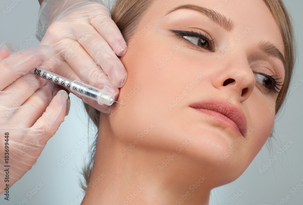Woman is getting filler injection in cheeks. Anti-aging treatment and face lift. Cosmetic Treatment and Plastic Surgery Woman is getting filler injection in cheeks. Anti-aging treatment and face lift. Cosmetic Treatment and Plastic Surgery