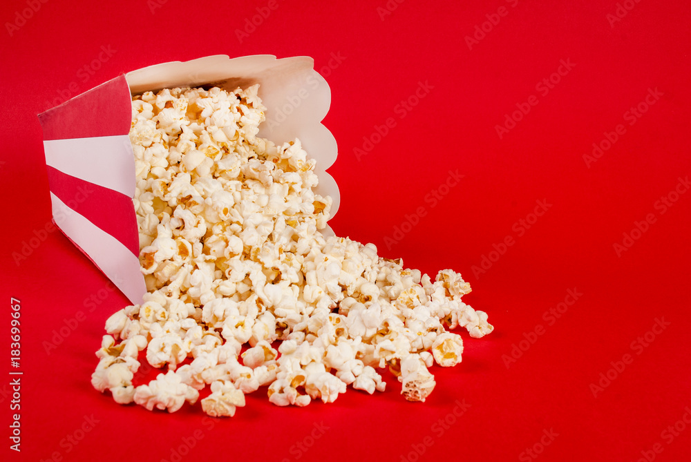 Popcorn spilled on red background