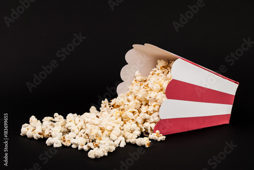 Popcorn spilled on black background