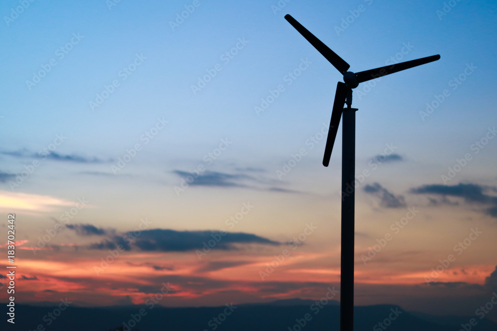A solitary Wind Turbine silhouetted against a dramatic sunset sky twilight time. A solitary Wind Turbine silhouetted against a dramatic sunset sky twilight time.