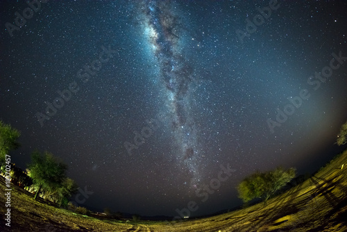 Starry sky and Milky Way arch, with details of its colorful core, outstandingly bright, captured from the Namib desert in Namibia, Africa. The Small Magellanic Cloud on the left hand side.