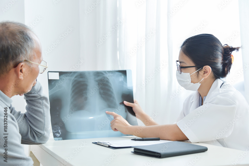 Young female doctor examining x-ray film. Young female doctor examining x-ray film.