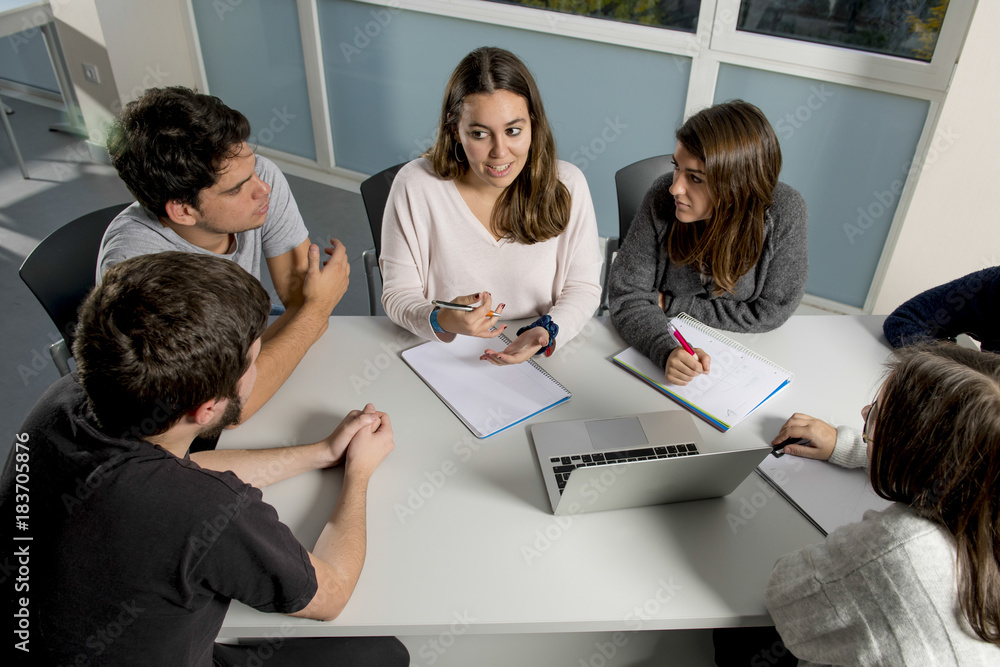 Obraz premium group of young male and female teenager university students at school sitting on classroom learning and working on project together