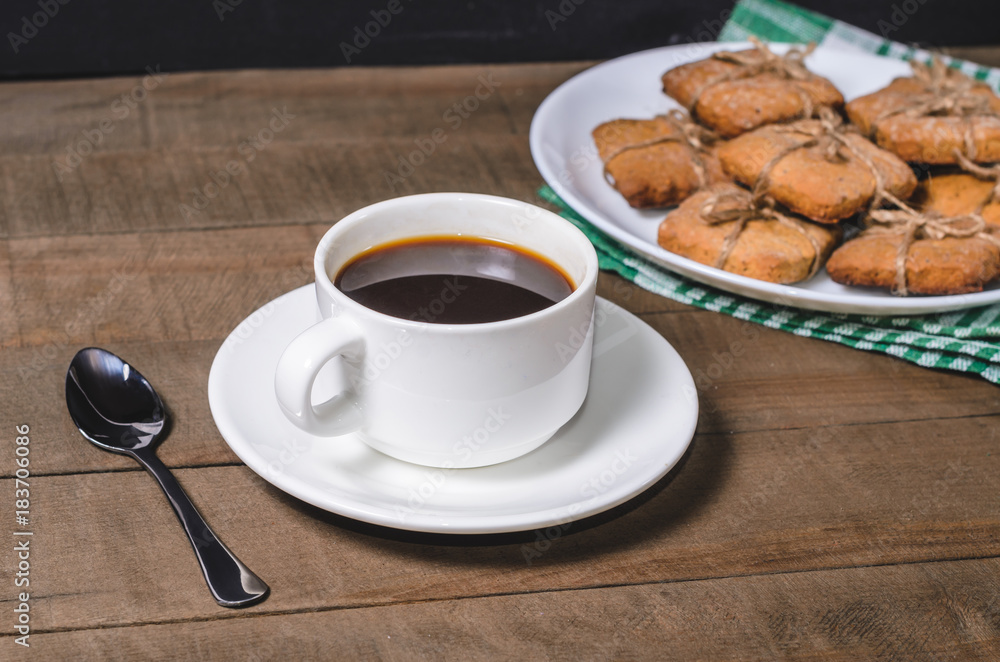 Black coffee in a white cup on a green napkin and homemade cookies. Black coffee in a white cup on a green napkin and homemade cookies.
