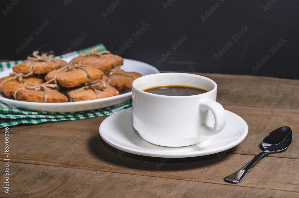 Black coffee in a white cup on a green napkin and homemade cookies. Black coffee in a white cup on a green napkin and homemade cookies.