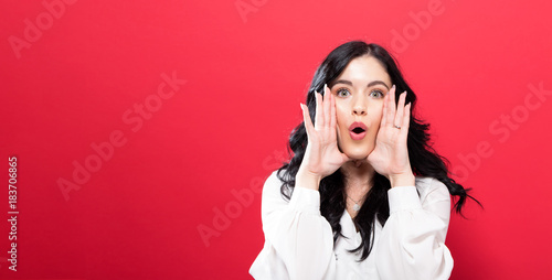 Φωτογραφία Young woman shouting an annoucment on a solid background
