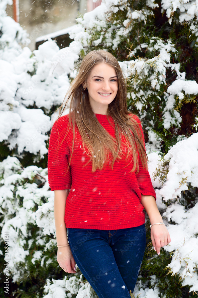 Girl in a sweater in a snowy park in winter. Girl in a sweater in a snowy park in winter.