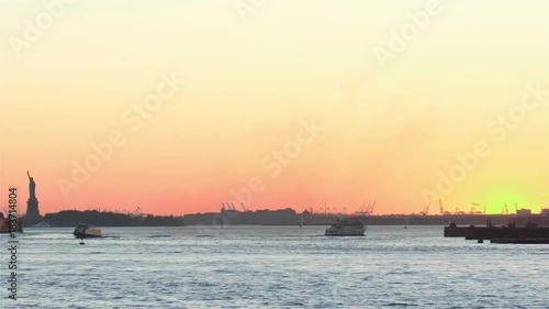 Fast motion New York Upper Bay at sunset in New York. Helicopters, aircrafts, ferris and yachts are making busy traffic. Statue of liberty in the left corner