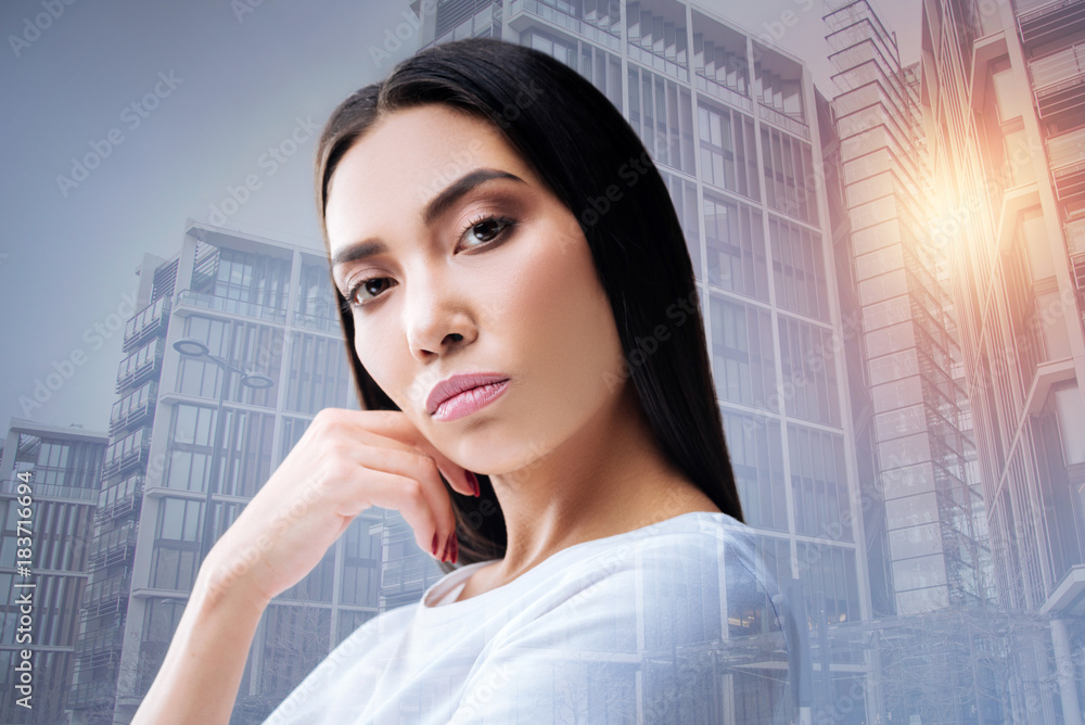 Fototapeta premium Attentive manager. Professional enthusiastic smart manager of a big company standing with her hand near the face and feeling disappointed with the lazy employees