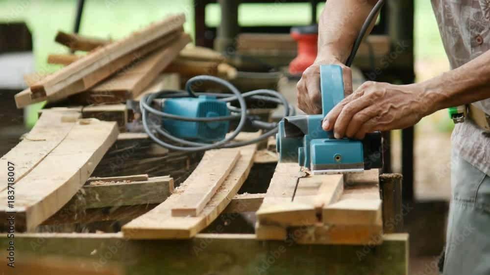 Closeup Carpenter Using Electric Plane Planing Wooden Plank Closeup Carpenter Using Electric Plane Planing Wooden Plank