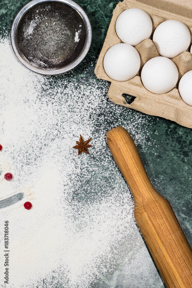 flour, berries and anise star spices as a decoration and rolling pin, eggs, strainer flour, berries and anise star spices as a decoration and rolling pin, eggs, strainer