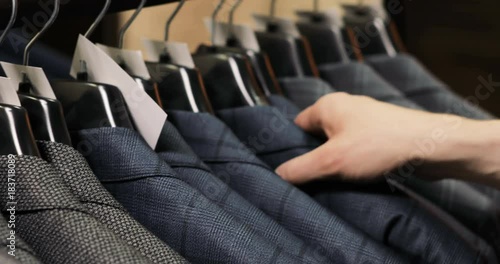 Man choosing a suit at tailor's shop photo