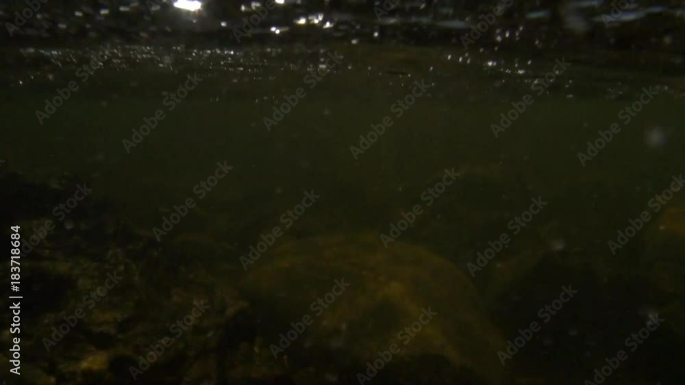Drops water on the video camera in mountain river Temnik in Siberia of Russia. Stone rock bottom in spring. Ecotourism in Siberia of Russia. Drops water on the video camera in mountain river Temnik in Siberia of Russia. Stone rock bottom in spring. Ecotourism in Siberia of Russia.