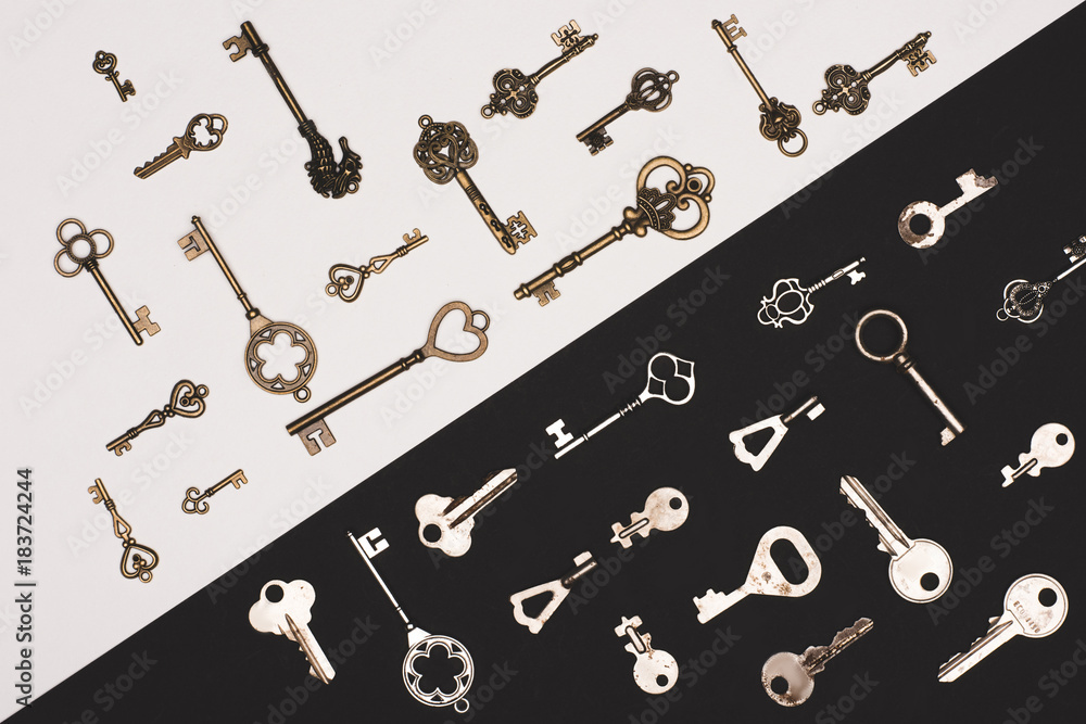 Naklejka premium top view of different vintage keys over black and white background