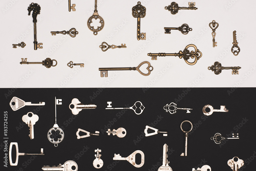 Obraz premium top view of different vintage keys over black and white background