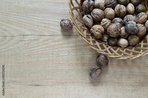 Walnuts in basket on wood table