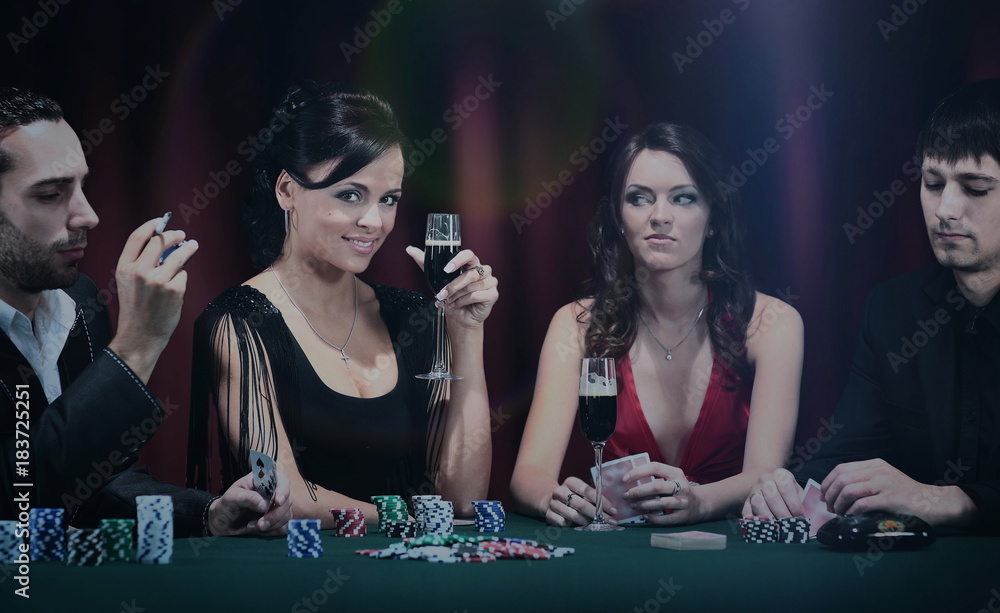 Poker players sitting around a table at a casino Poker players sitting around a table at a casino