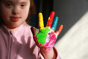 Down syndrome girl with painted hands