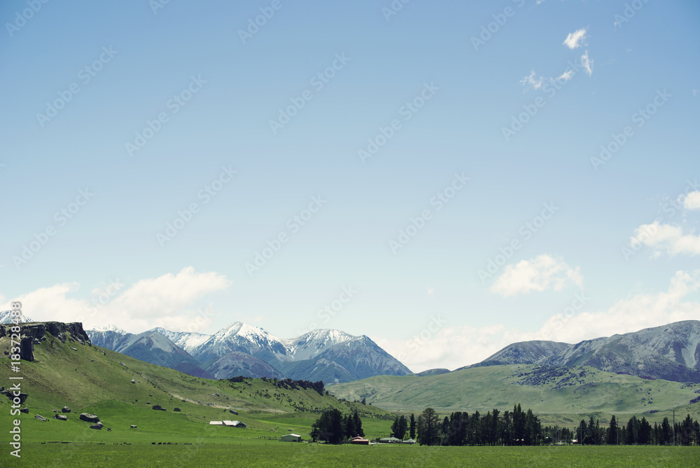 Paisaje montañoso con una pradera verde en un día soleado con algunas nubes y cielo azul. Paisaje montañoso con una pradera verde en un día soleado con algunas nubes y cielo azul.