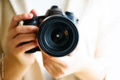 Girl hands holding photo camera, white background, copy space. Travel and shoot concept photo