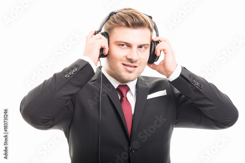 Young manager wearing suit putting on headphones