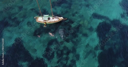 Wallpaper Mural Aerial, a family swimming near their sailing ship in a beautiful bay with crystalline water Torontodigital.ca