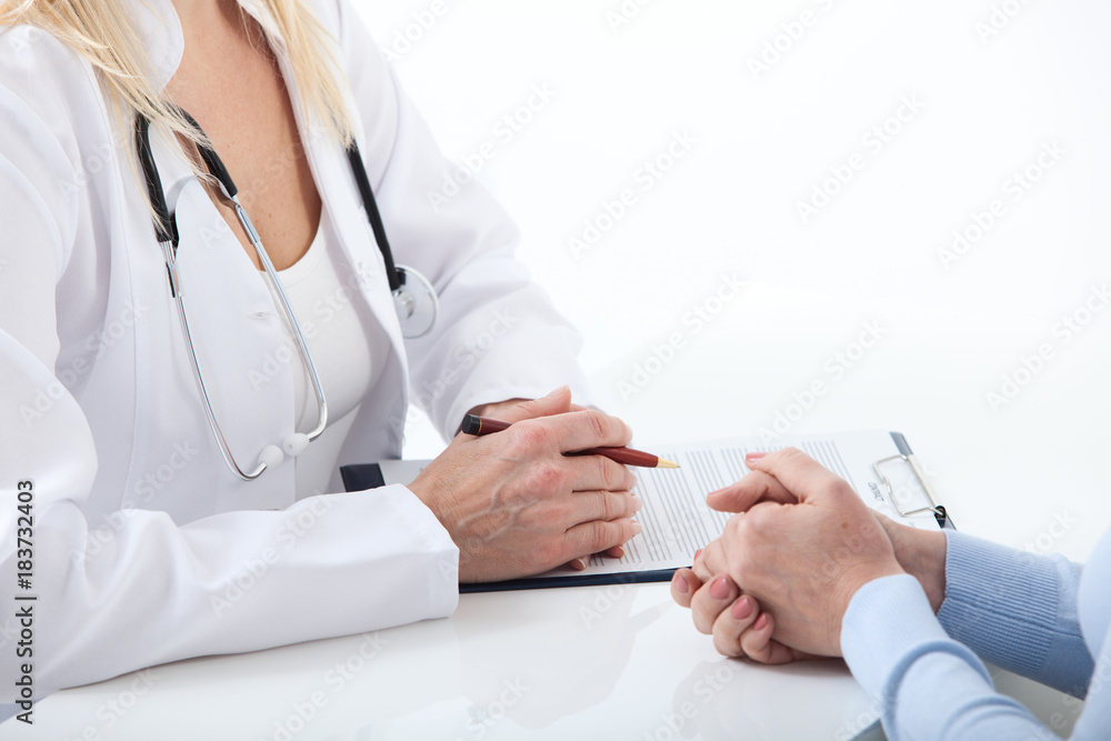Naklejka premium Doctor and patient are discussing something, just hands at the table close up