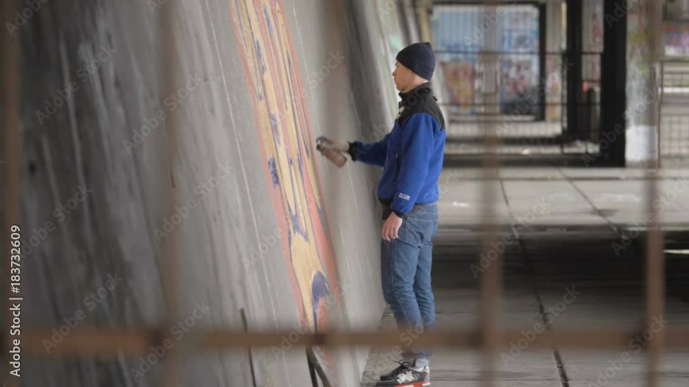 Graffiti. A young guy draws on the wall. Graffiti. A young guy draws on the wall.