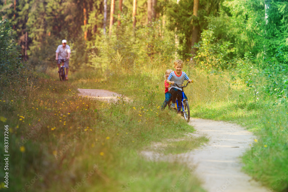 active senior with grandkids riding bikes in nature active senior with grandkids riding bikes in nature