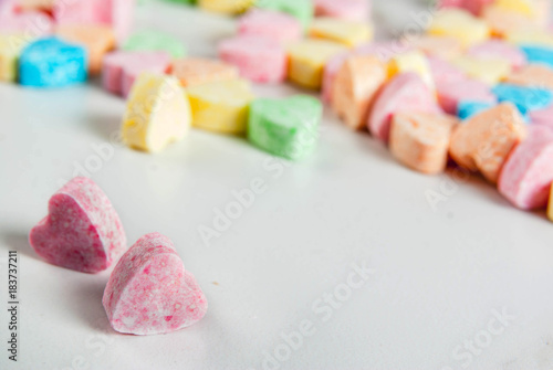 Valentine's day concept, sweet sugar candy on dorm of hearts, on white marble table, copy space, greeting card background